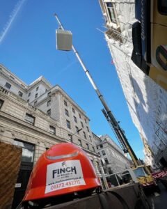 Machine movers lifting a containerised generator with attenuation and silencer to a London roof