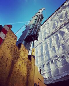 A containerized generator with attenuation and silencer lifted to a London roof