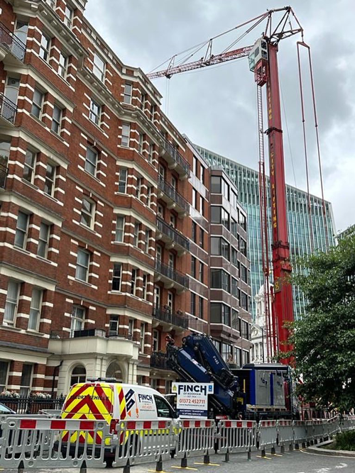 Finch Contract Lifting Services with Crane Next to Red Building